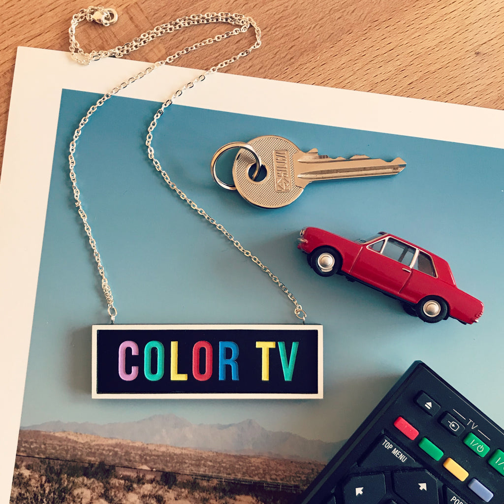 color tv sign necklace with toy car