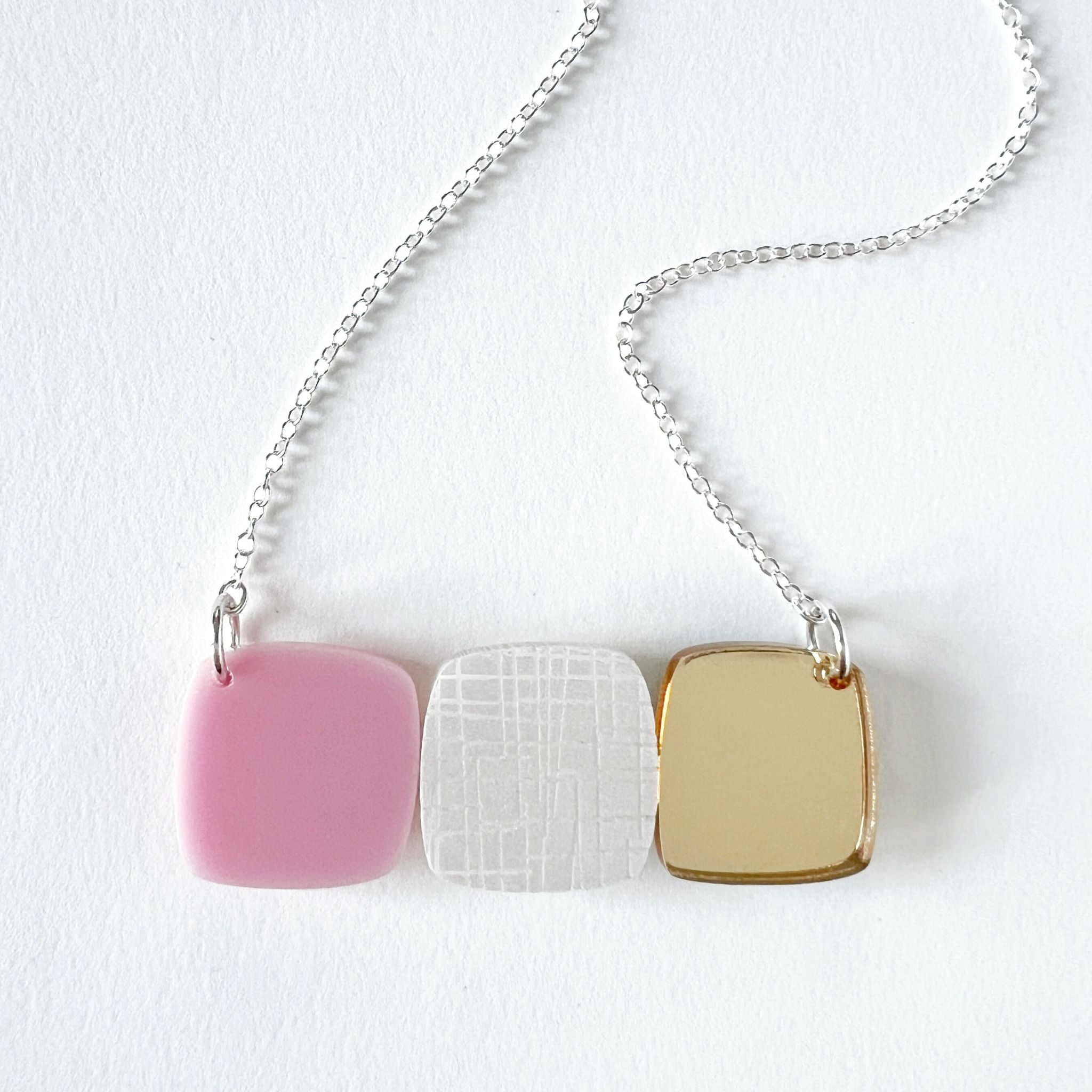 Midcentury style abstract necklace with three layered acrylic pebble-shaped pieces on a sterling silver chain