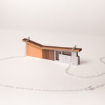 orange butterfly roof house necklace with silver chain on a white background